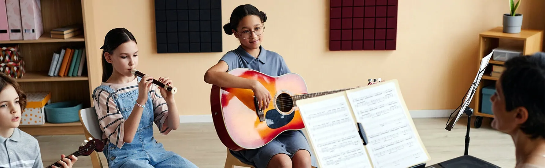 children listening at teacher in a music lesson