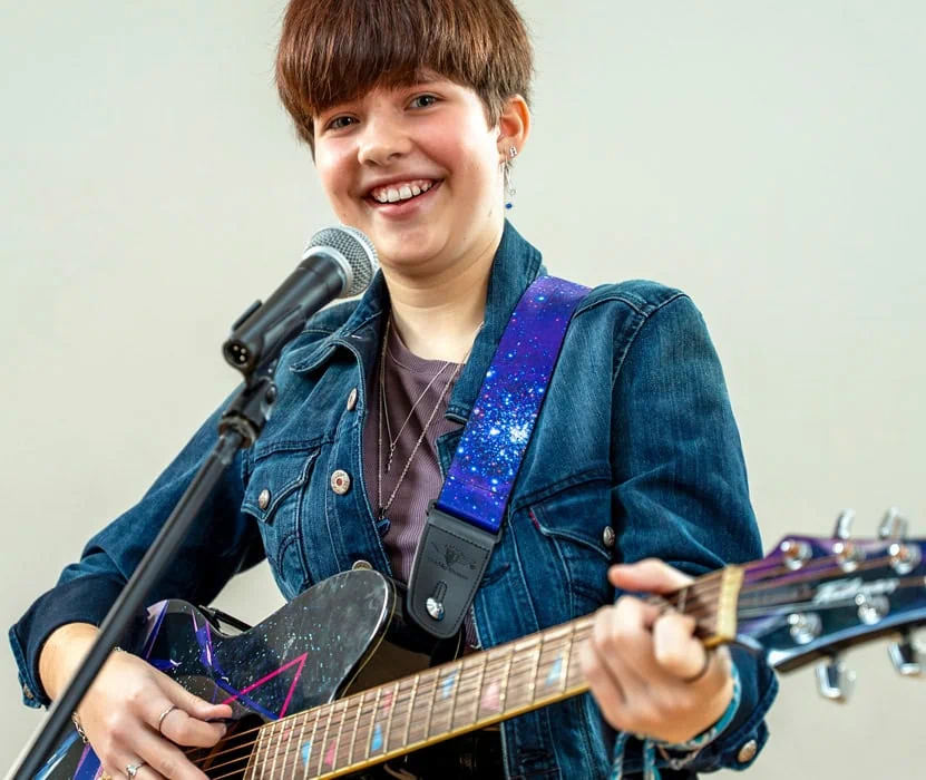 young girl playing guitar and singing
