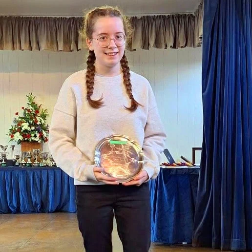 Young girl holding a glass award at a music event in Shropshire.