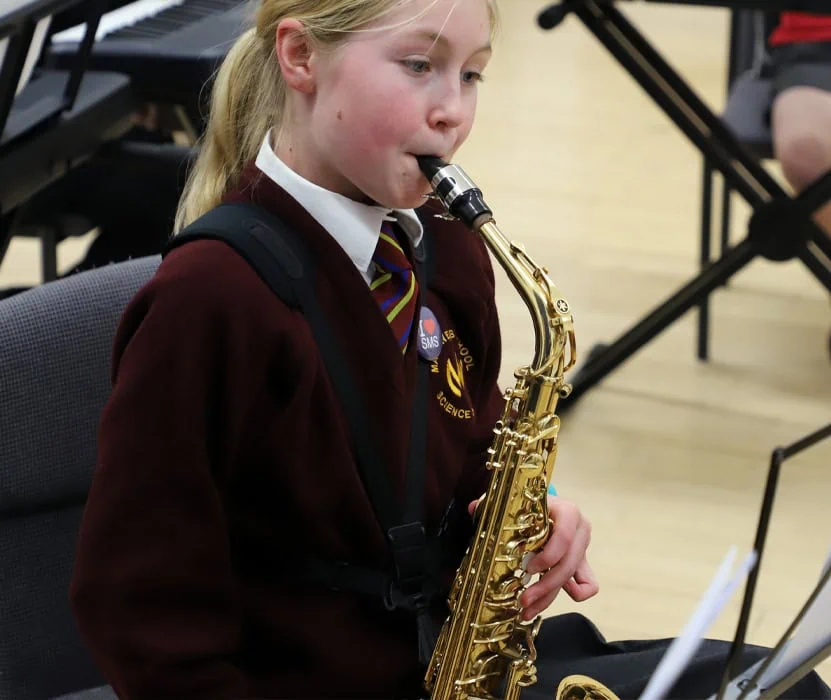 girl playing saxophone in a lesson