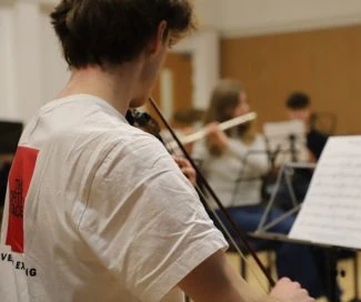 Young musicians practicing with string instruments in a music room.